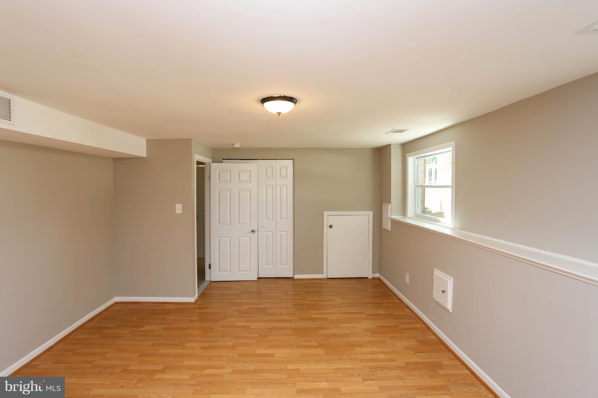 512 Crosby Road Baltimore, MD 21228 - Photo 21 of 30 a view of an empty room with wooden floor and a window