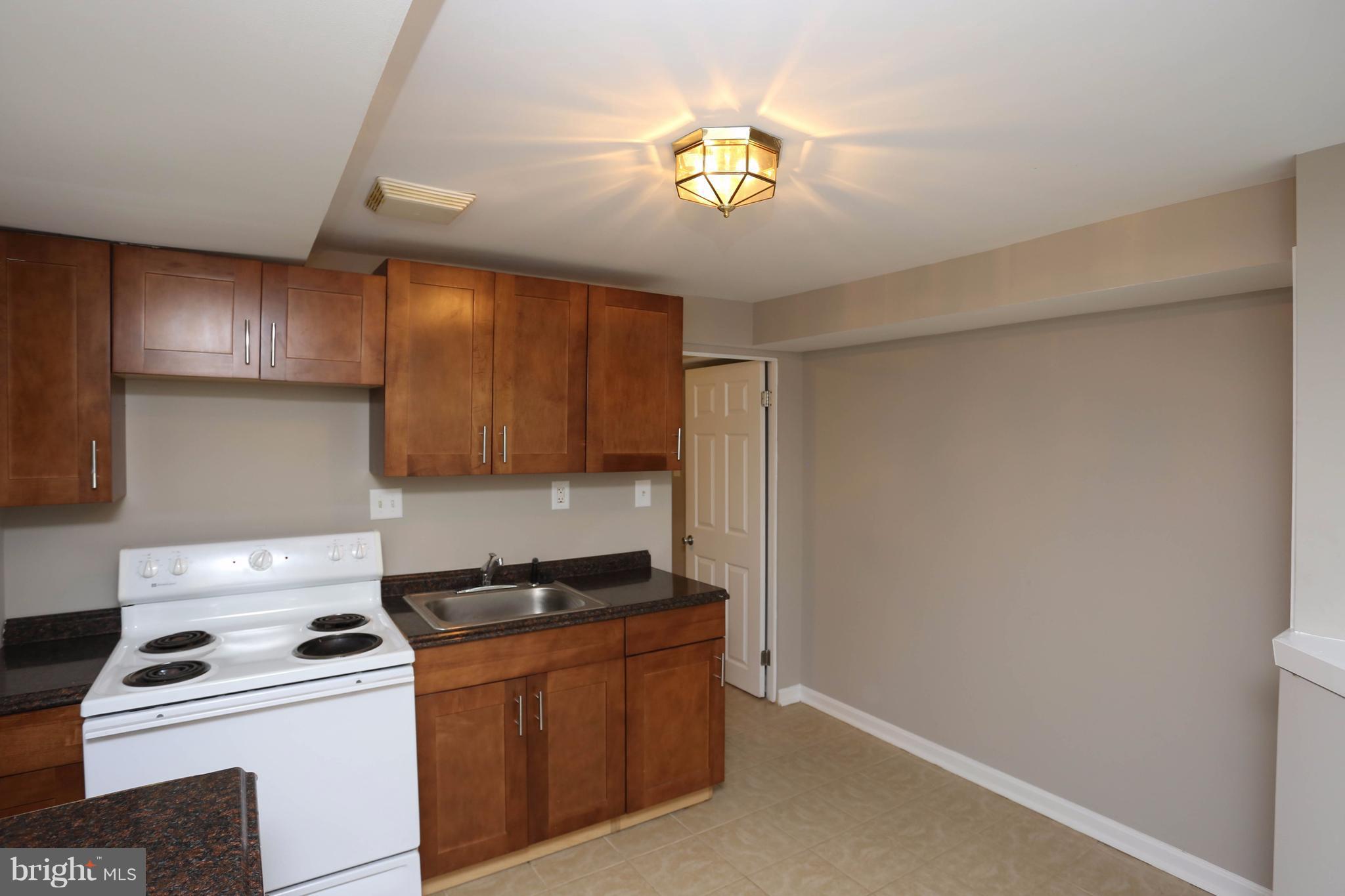 512 Crosby Road Baltimore, MD 21228 - Photo 27 of 30 a kitchen with a stove and a refrigerator