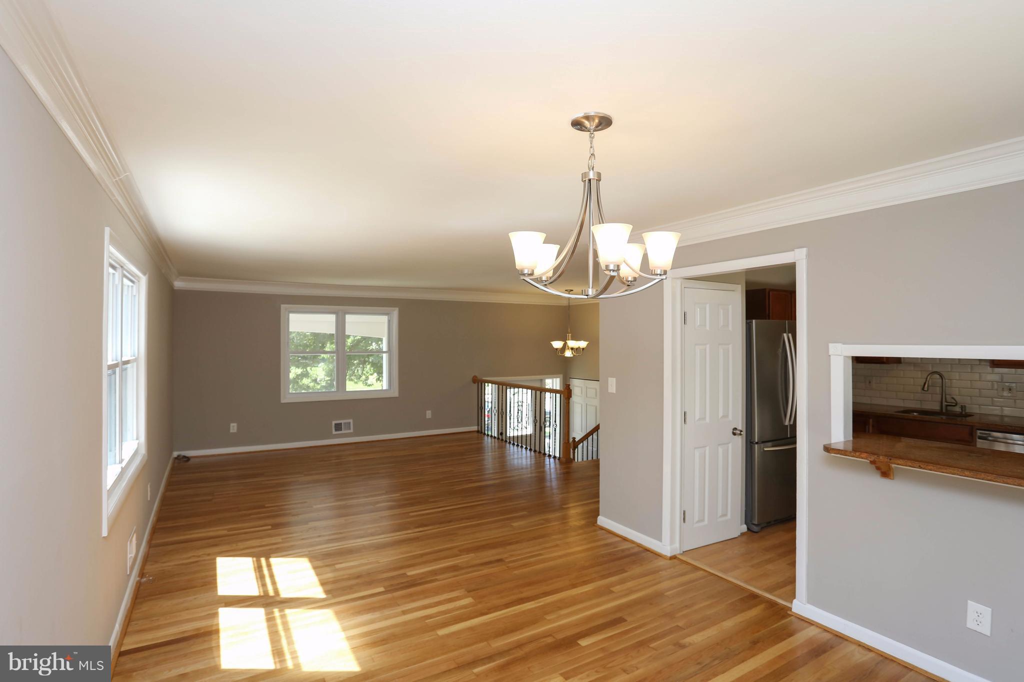 512 Crosby Road Baltimore, MD 21228 - Photo 8 of 30 a view of a livingroom with wooden floor and chandelier