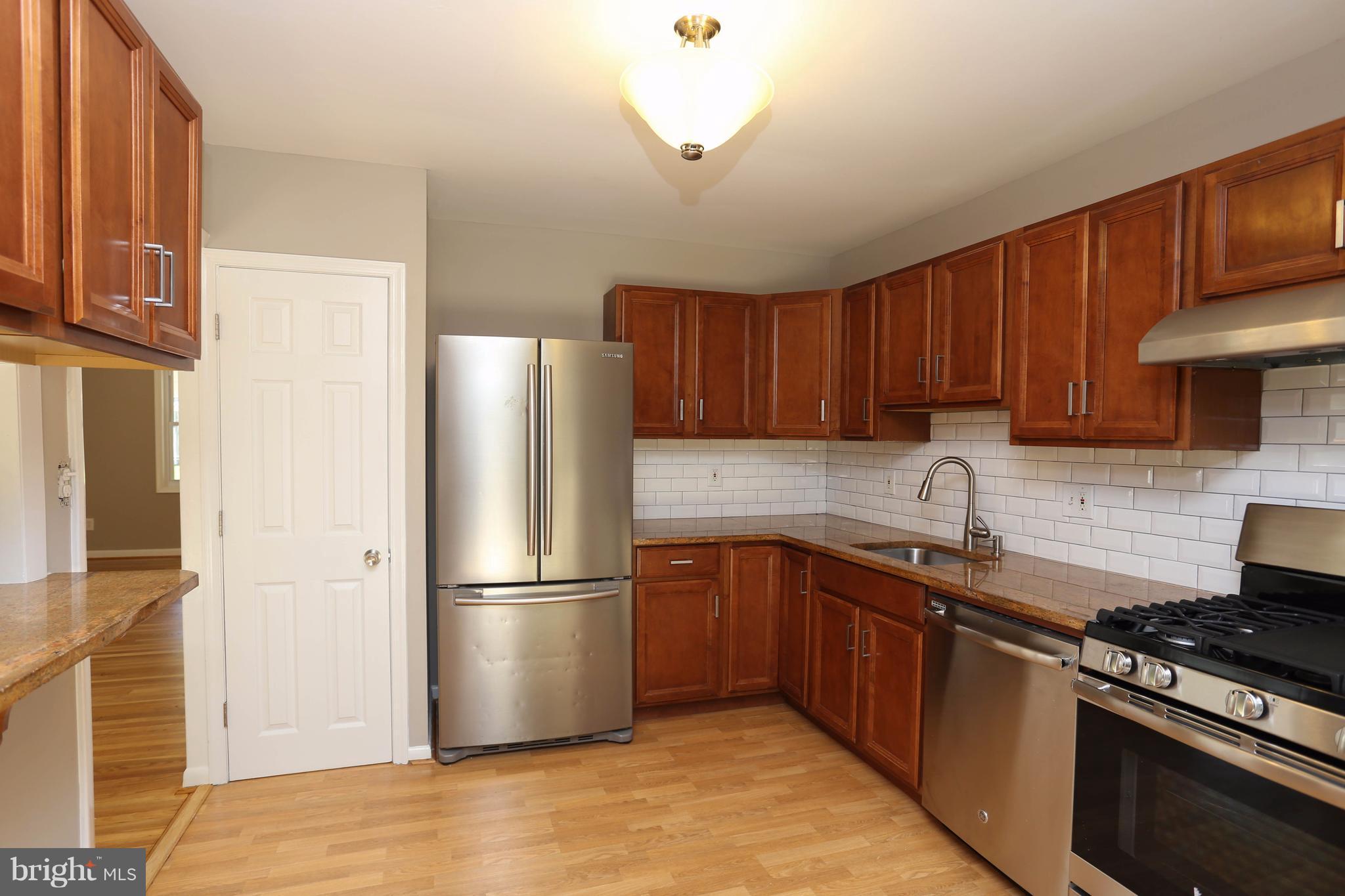 512 Crosby Road Baltimore, MD 21228 - Photo 10 of 30 a kitchen with stainless steel appliances granite countertop a stove a refrigerator and a sink