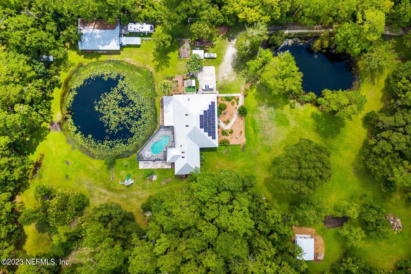 1100 Oak Ridge Road St. Augustine, FL 32086 - Photo 1 of 95 an aerial view of residential house with swimming pool and lawn chairs