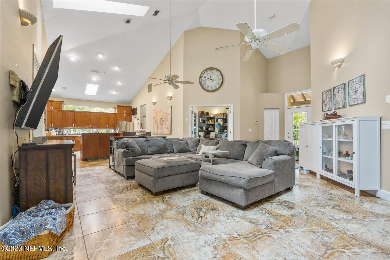 1100 Oak Ridge Road St. Augustine, FL 32086 - Photo 12 of 95 a living room with couches a dining table and kitchen view with wooden floor