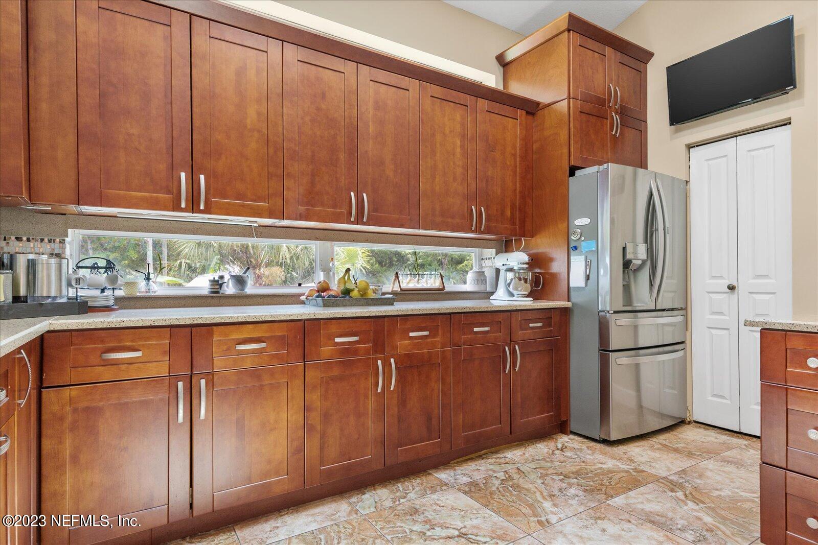 1100 Oak Ridge Road St. Augustine, FL 32086 - Photo 18 of 95 a kitchen with stainless steel appliances granite countertop a refrigerator a stove and a sink with wooden cabinets