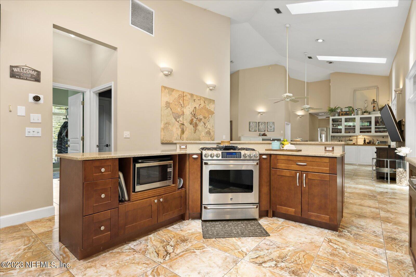 1100 Oak Ridge Road St. Augustine, FL 32086 - Photo 19 of 95 a kitchen with stainless steel appliances kitchen island granite countertop a stove and a sink