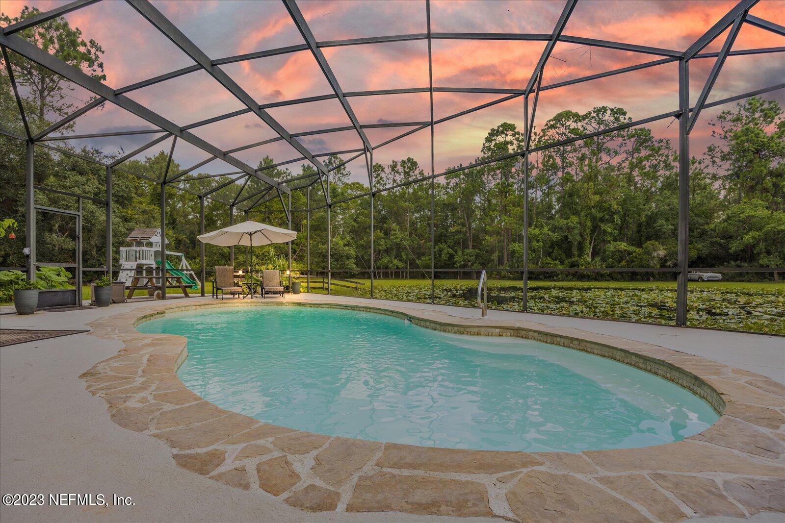 1100 Oak Ridge Road St. Augustine, FL 32086 - Photo 3 of 95 a view of a swimming pool with a patio