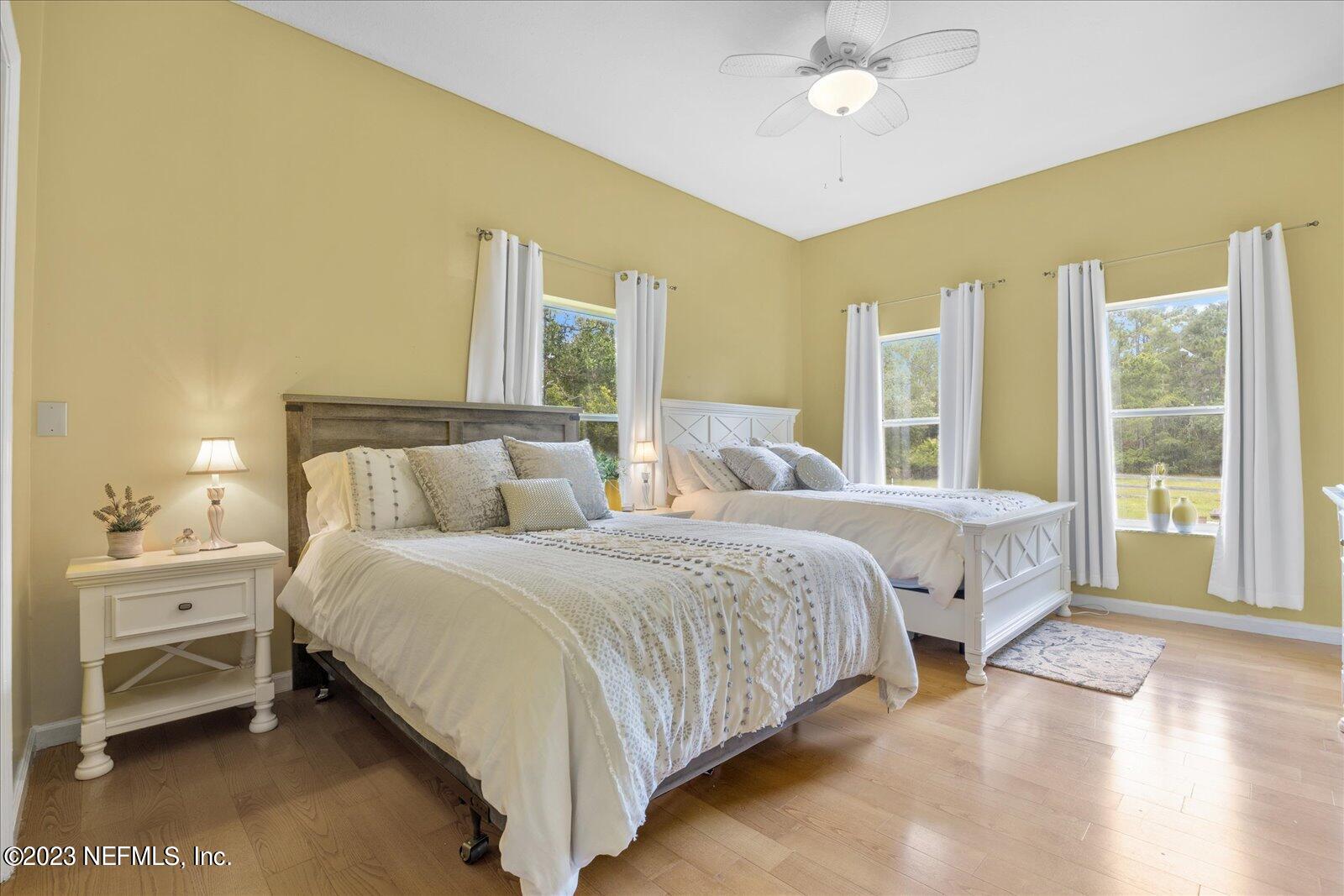 1100 Oak Ridge Road St. Augustine, FL 32086 - Photo 33 of 95 a spacious bedroom with a bed and a chandelier