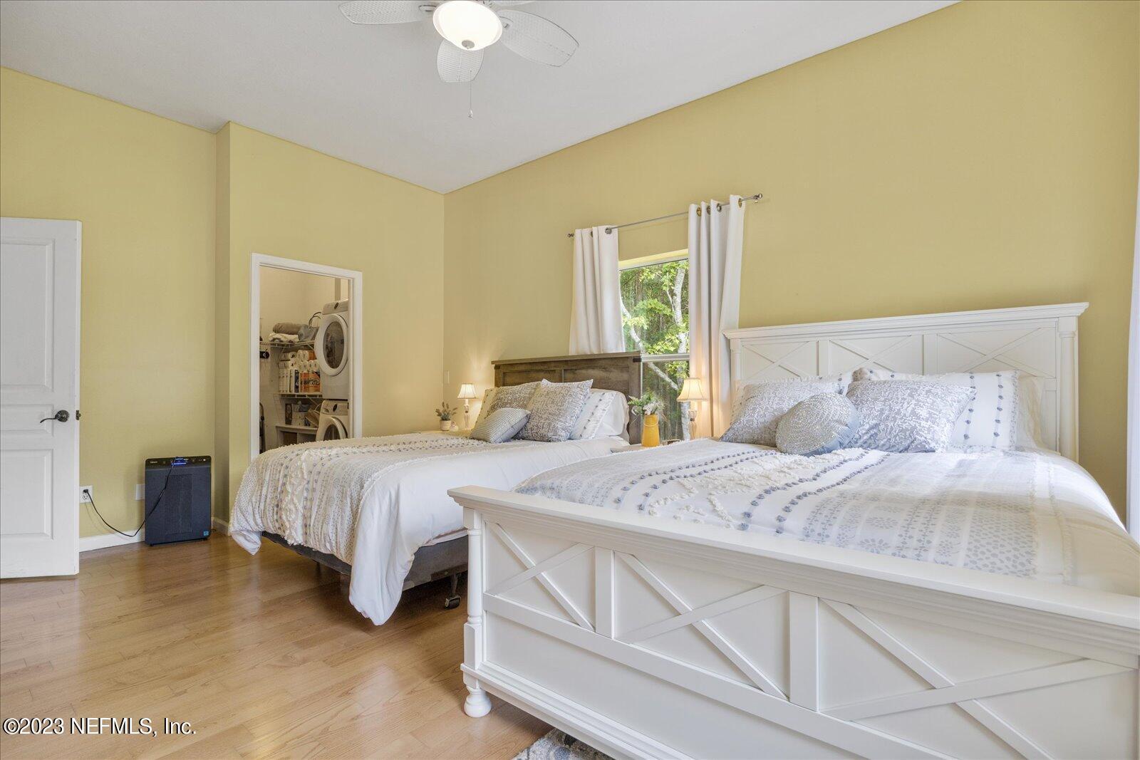 1100 Oak Ridge Road St. Augustine, FL 32086 - Photo 35 of 95 a bedroom with a bed and a chandelier