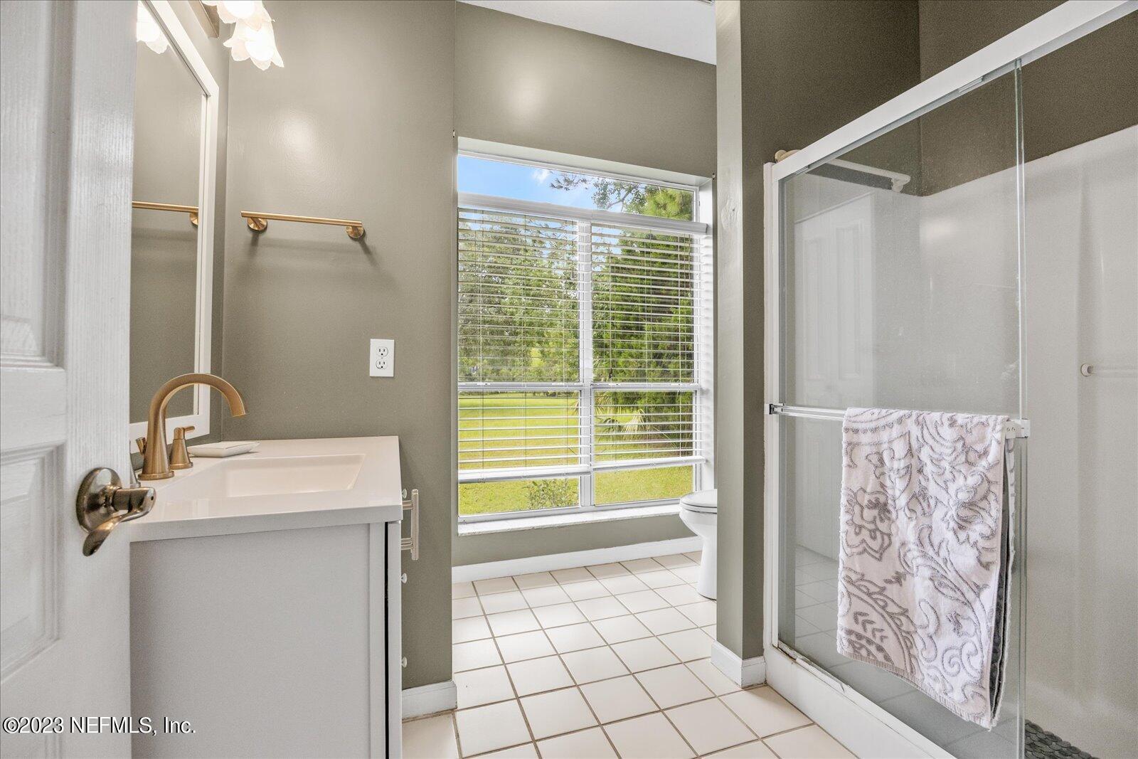 1100 Oak Ridge Road St. Augustine, FL 32086 - Photo 37 of 95 a bathroom with a granite countertop sink a toilet and shower