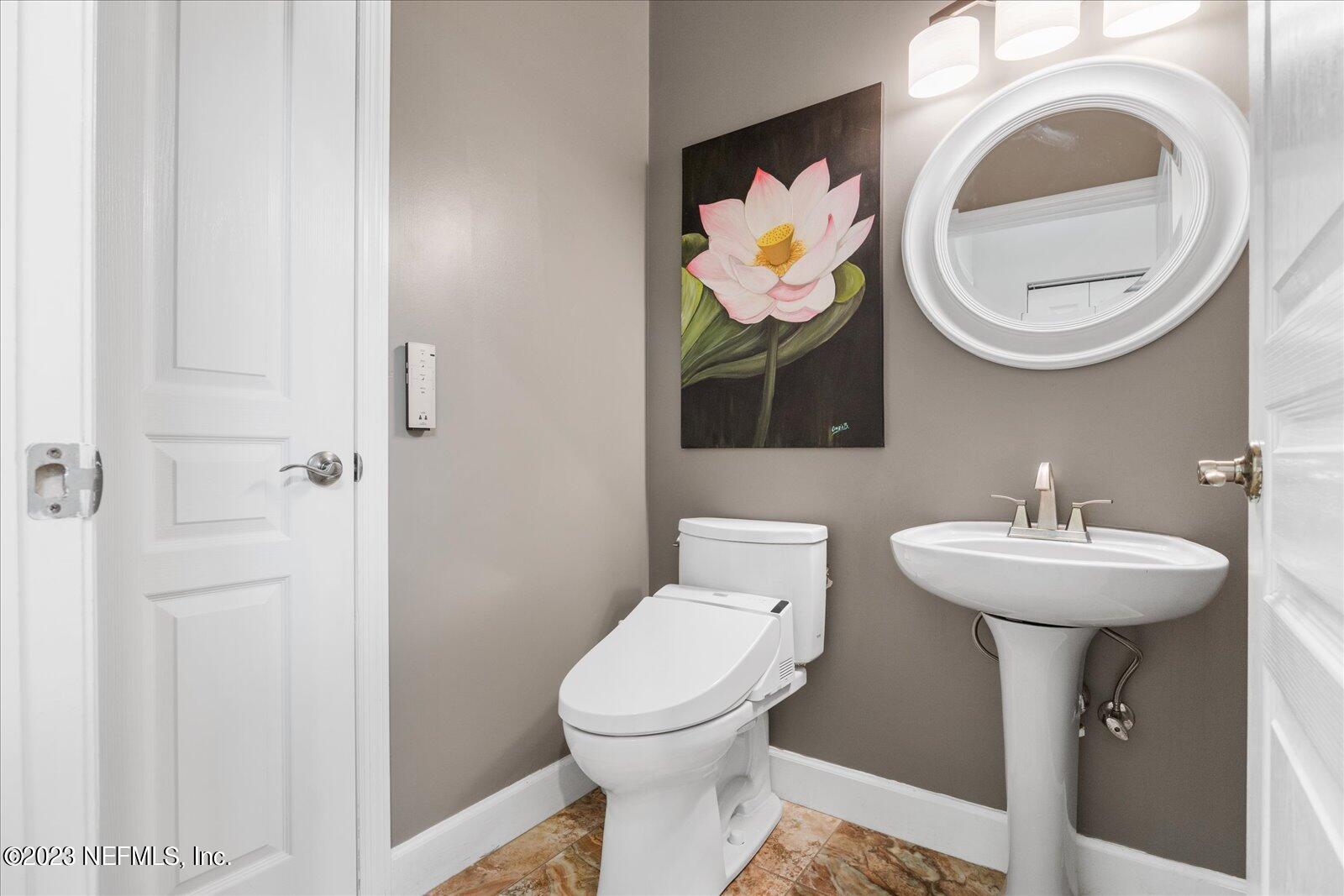 1100 Oak Ridge Road St. Augustine, FL 32086 - Photo 55 of 95 a bathroom with a toilet sink and mirror