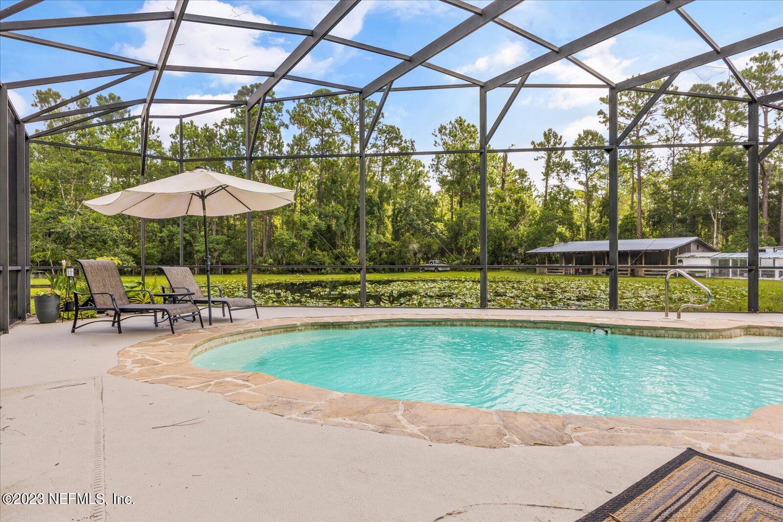1100 Oak Ridge Road St. Augustine, FL 32086 - Photo 62 of 95 a view of a swimming pool with a patio and a yard