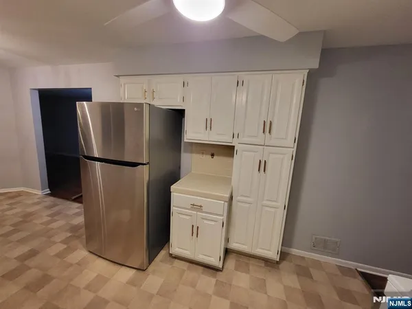 a kitchen with a refrigerator sink and cabinets