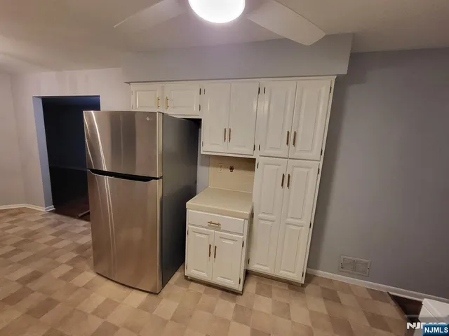 a kitchen with a refrigerator sink and cabinets