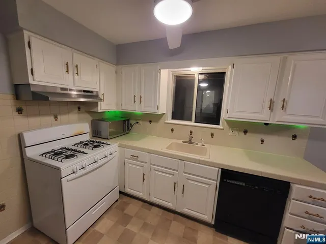 a kitchen with cabinets a sink and appliances