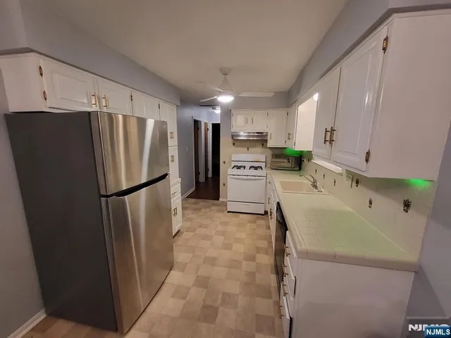 a kitchen with stainless steel appliances a refrigerator sink and cabinets