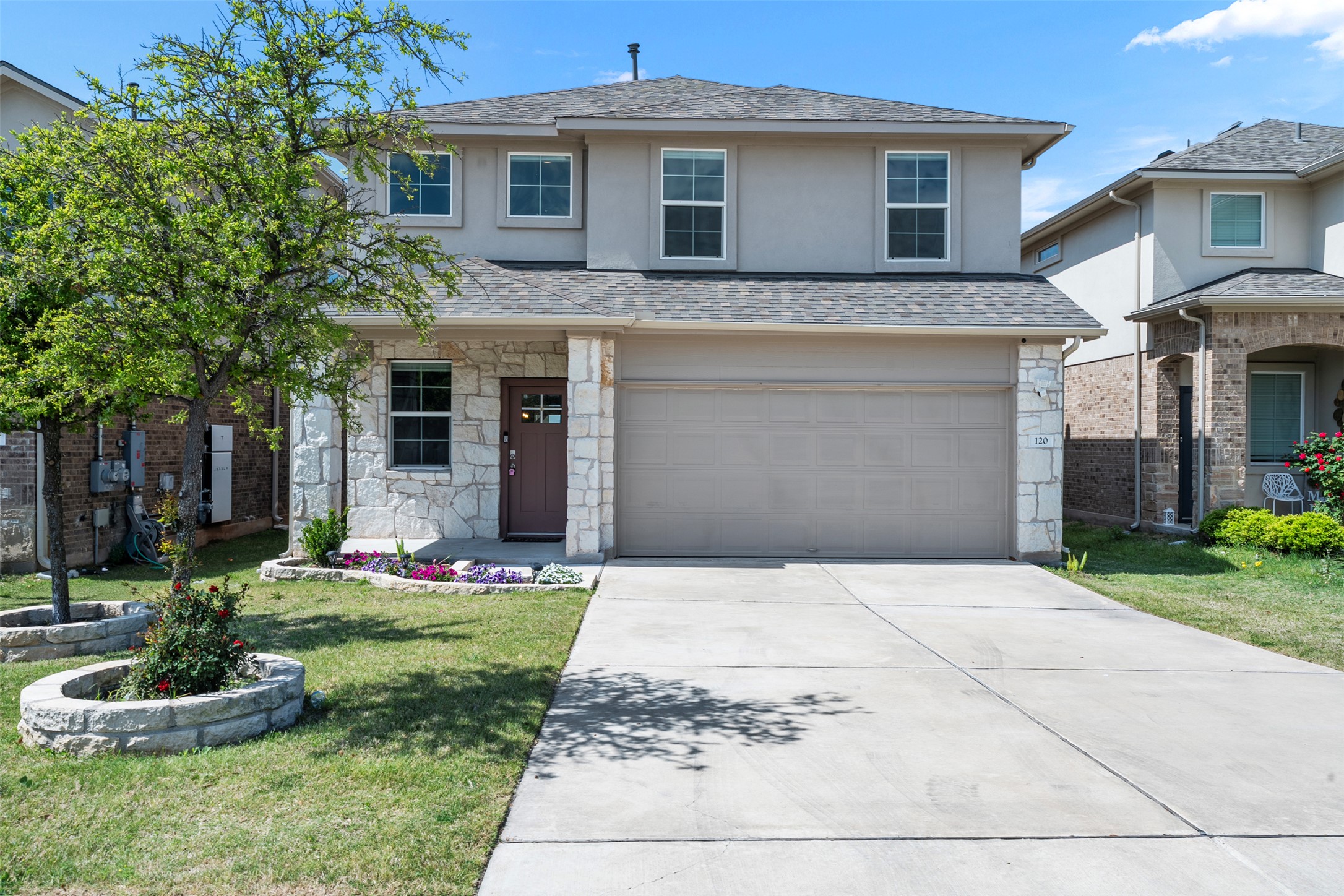 120 Ellinger Road Georgetown, TX 78626 - Photo 26 of 28 Two-story stucco and stone exterior featuring a covered entry porch, a two-car garage, and a concrete driveway