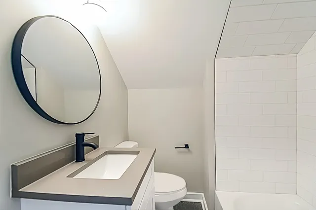 a bathroom with a toilet a sink and a mirror