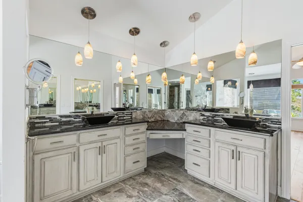 a spacious bathroom with a granite countertop sink mirror and a