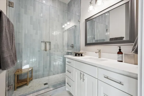 a bathroom with a granite countertop sink mirror and shower