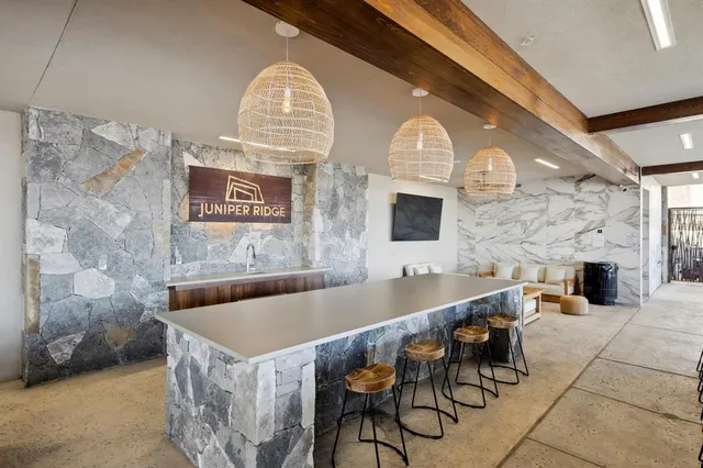a living room with couches a fireplace and a dining table with a large window