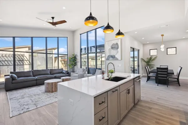 a kitchen with stainless steel appliances granite countertop a sink and a large window