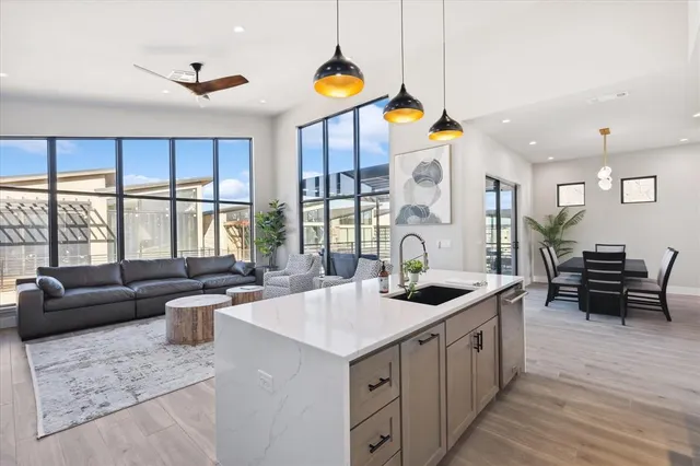 a kitchen with stainless steel appliances granite countertop a sink and a large window