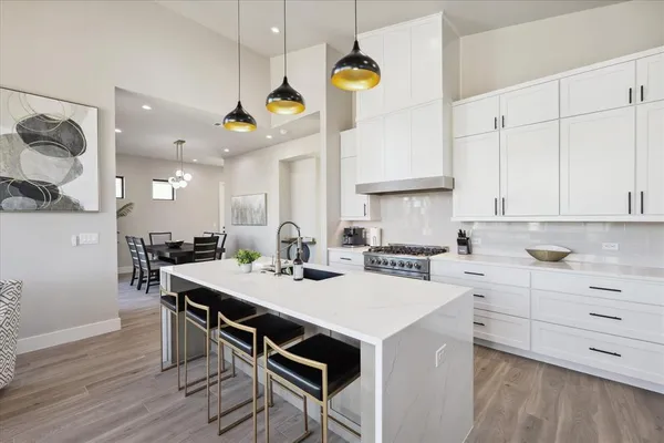 a kitchen with a stove a table and chairs in it