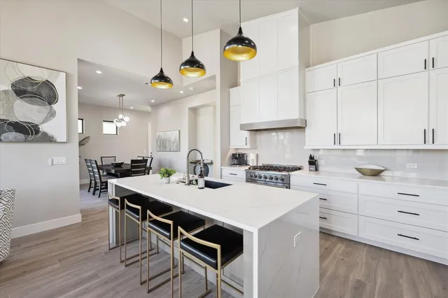 a kitchen with a stove a table and chairs in it
