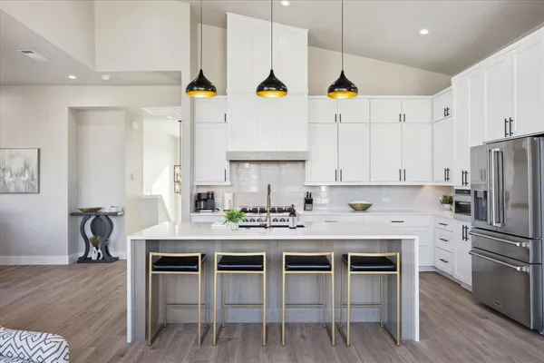 a kitchen with stainless steel appliances kitchen island granite countertop a table chairs stove and cabinets