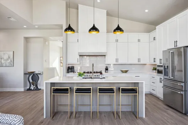 a kitchen with stainless steel appliances kitchen island granite countertop a table chairs stove and cabinets