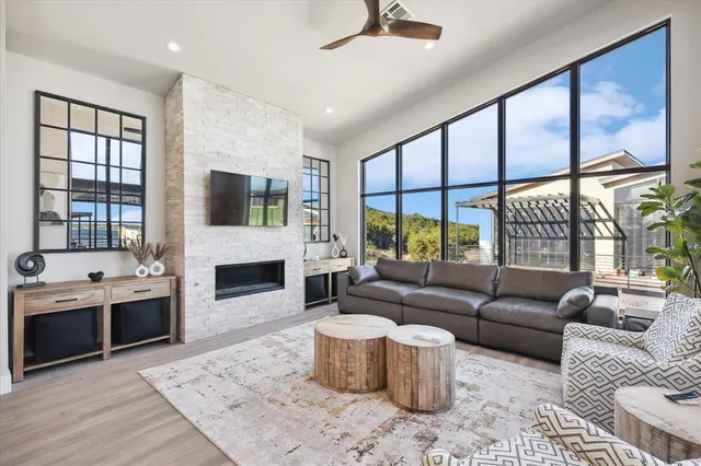 a living room with furniture a fireplace and a floor to ceiling window