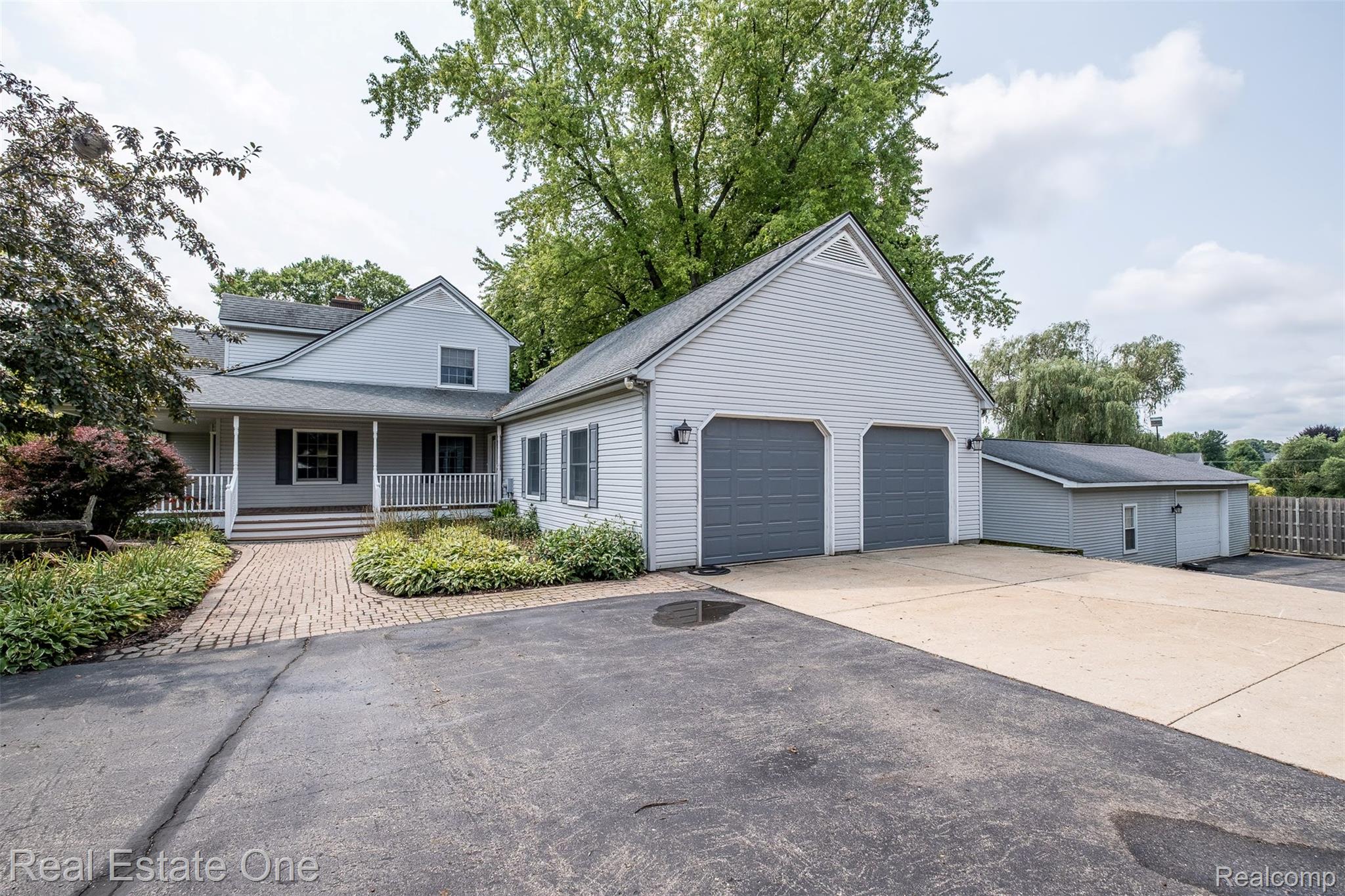 11030 Marshall Road South Lyon, MI 48178 - Photo 11 of 83 Light gray exterior siding with a covered front porch featuring white railings