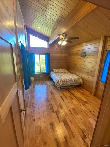 a backyard of a house with wooden floor barbeque oven and chairs