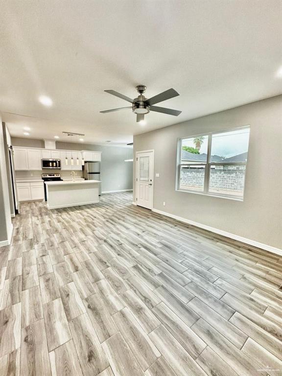 5402 North Crown Point Pharr, TX 78577 - Photo 4 of 19 an empty room with wooden floor fan and windows