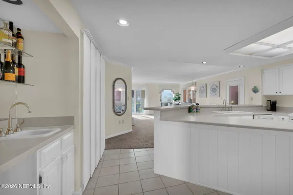 a large kitchen with kitchen island a sink a counter top space and cabinets