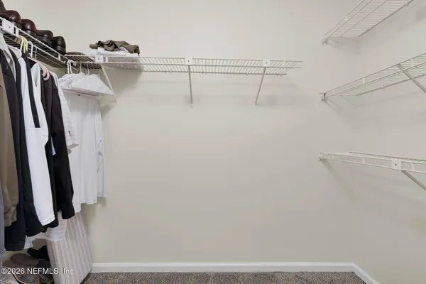 a view of walk in closet with clothes and shoes