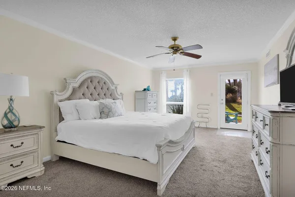 a spacious bedroom with a bed and a flat screen tv