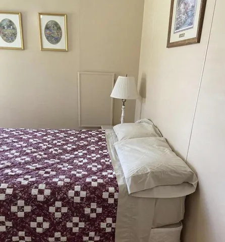 a bedroom with a bed and a lamp on dresser