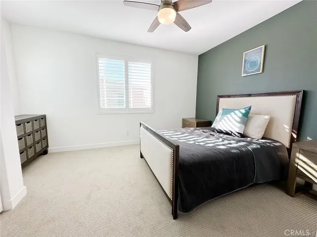 a spacious bedroom with a bed a couch and a ceiling fan