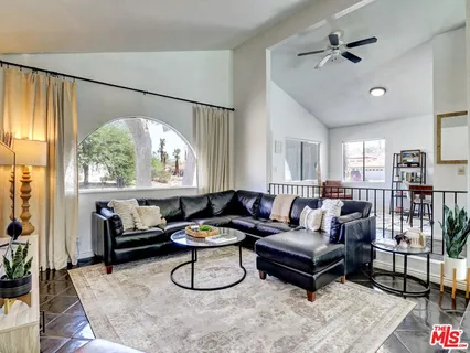 a living room with furniture a table and a large window