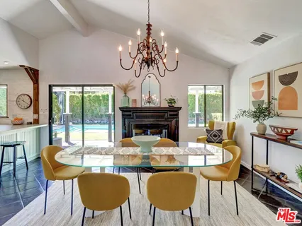 a view of a dining room with furniture a chandelier and wooden floor