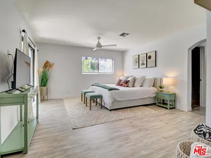 a bedroom with a bed window and a flat screen tv