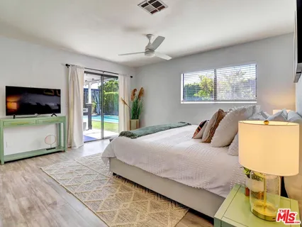 a bedroom with a bed and large window