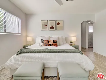 a bedroom with a bed and painting on the wall