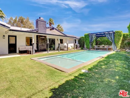 a view of a house with a backyard and a patio