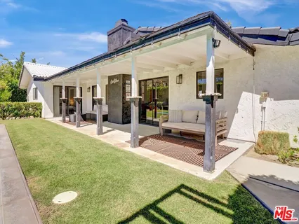 a view of a patio with table and chairs potted plants with wooden floor and fence