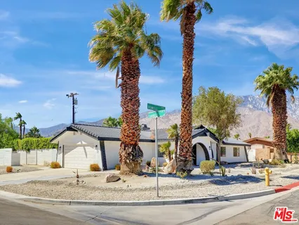 a house view with a garden and trees