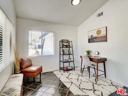 a living room with furniture a piano and a window