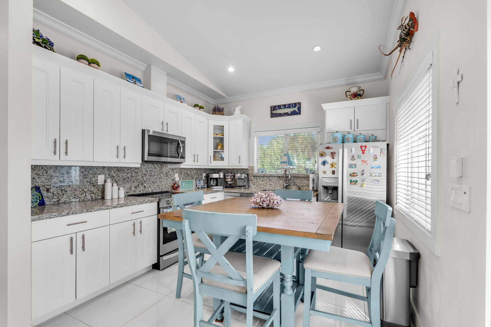 22 Tarpon Avenue Key Largo, FL 33037 - Photo 18 of 43 a dining room with stainless steel appliances granite countertop a kitchen island hardwood floor sink stove and white cabinets