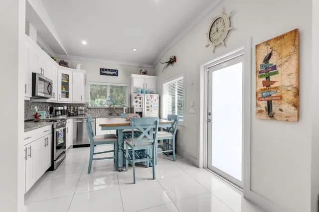 a kitchen with stainless steel appliances kitchen island granite countertop a refrigerator and cabinets