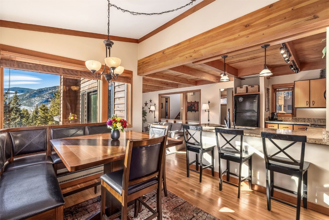 410 Tennis Club Road, Unit 1317 Keystone, CO 80435 - Photo 29 of 47 Dining room with a mountain view, light wood-style flooring, a chandelier, a wood ceiling with exposed beams, and track lighting